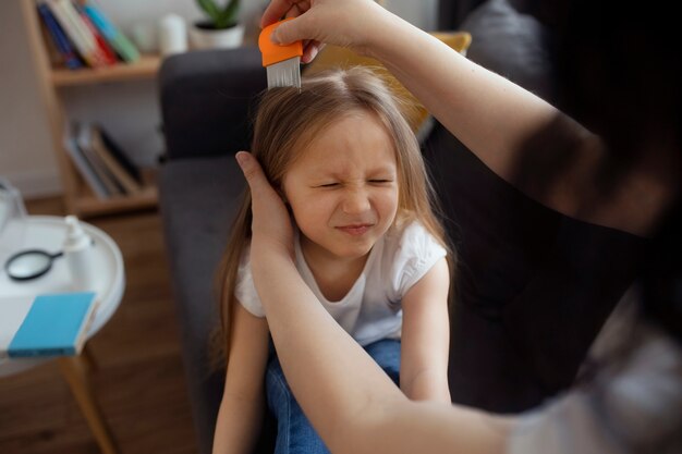 Mutter kümmert sich um Kind mit Kopfläusen