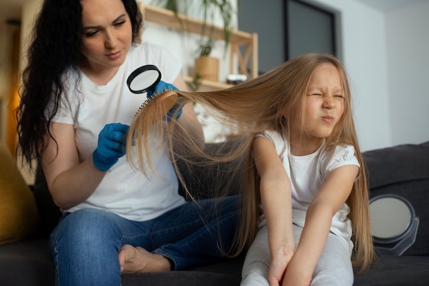 Mutter kümmert sich um Kind mit Kopfläusen