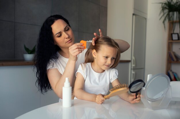 Mutter kümmert sich um Kind mit Kopfläusen