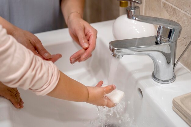 Mutter lehrt Kind, ihre Hände zu waschen