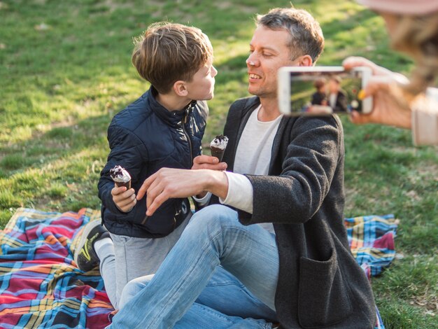 Mutter macht ein Foto von Vater und Sohn