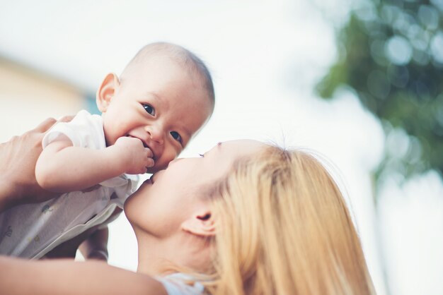 Mutter mit Baby, lachend und im Park spielend