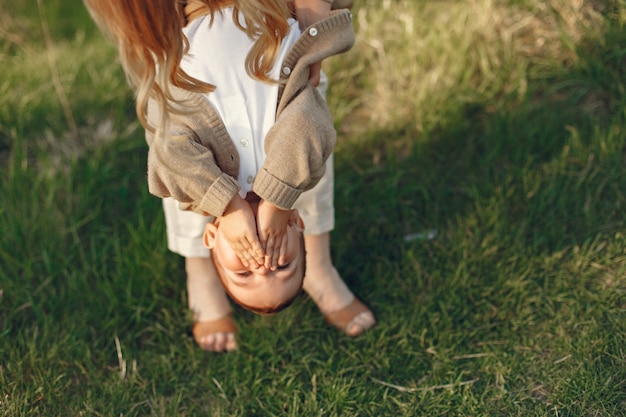 Mutter mit dem kleinen Sohn, der in einem Sommerfeld spielt