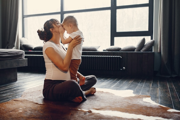 Mutter mit dem kleinen Sohn, der zu Hause Yoga tut