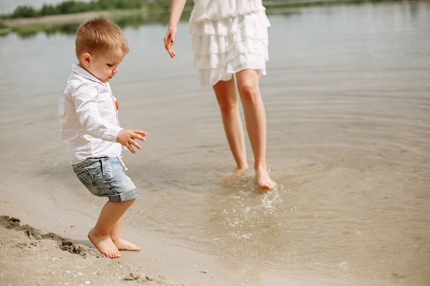 Mutter mit dem Sohn, der in einem Sommerpark spielt