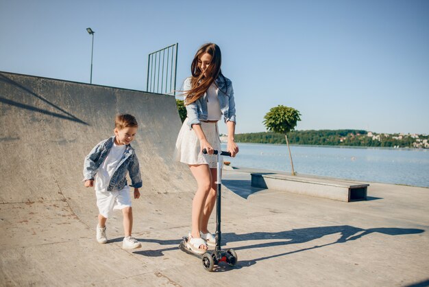 Mutter mit dem Sohn, der in einem Sommerpark spielt