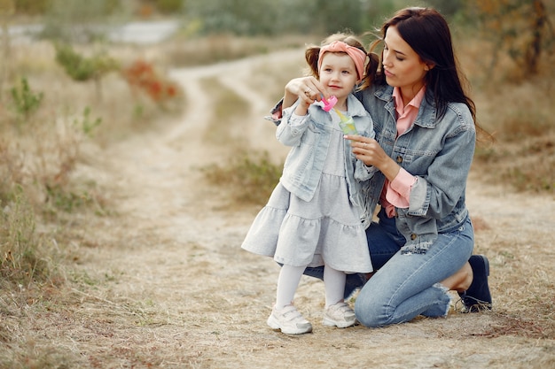 Kostenloses Foto mutter mit der kleinen tochter, die auf einem gebiet spielt