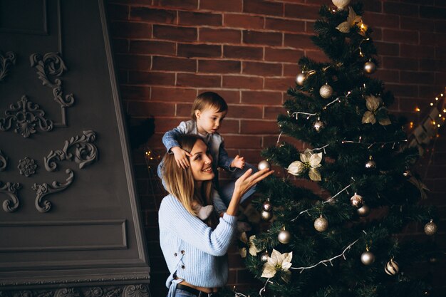 Mutter mit der kleinen Tochter, die Weihnachtsbaum verziert