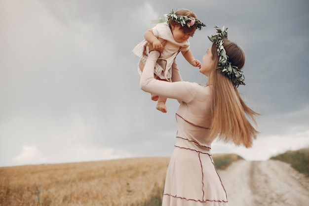 Mutter mit der Tochter, die auf einem Sommergebiet spielt