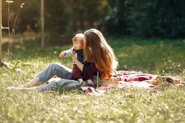 Mutter mit der Tochter, die in einem Sommerpark spielt