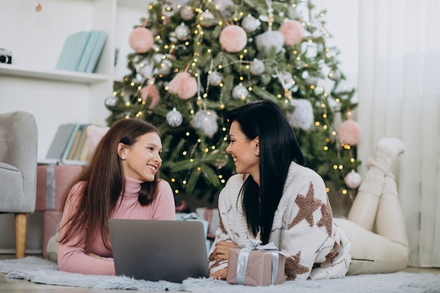 Mutter mit der Tochter, die online auf Weihnachten kauft