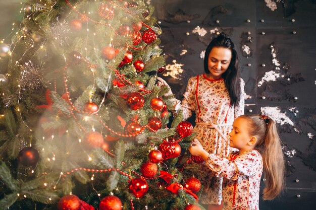 Mutter mit der Tochter, die Weihnachtsbaum verziert