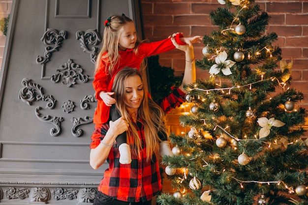 Mutter mit der Tochter, die Weihnachtsbaum verziert