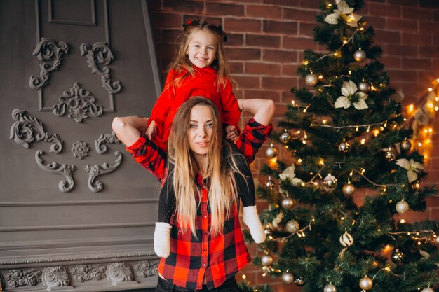 Mutter mit der Tochter, die Weihnachtsbaum verziert