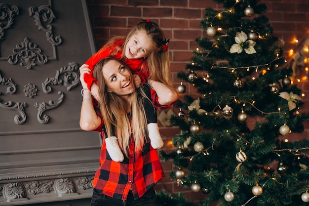 Mutter mit der Tochter, die Weihnachtsbaum verziert