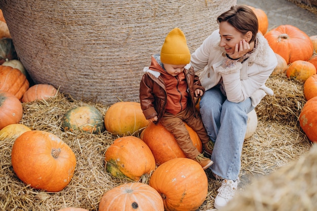 Mutter mit ihrem kleinen Sohn bei den Kürbissen an Halloween