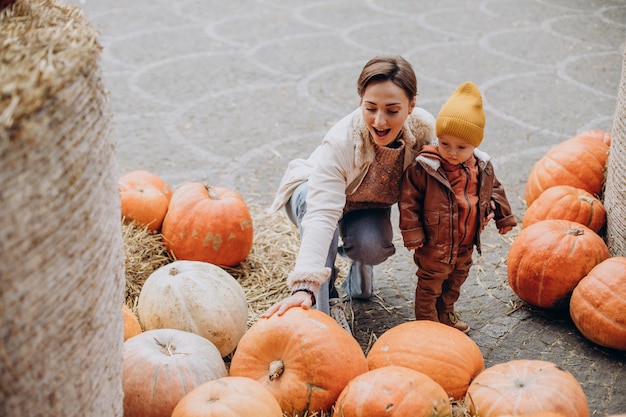 Mutter mit ihrem kleinen Sohn bei den Kürbissen an Halloween