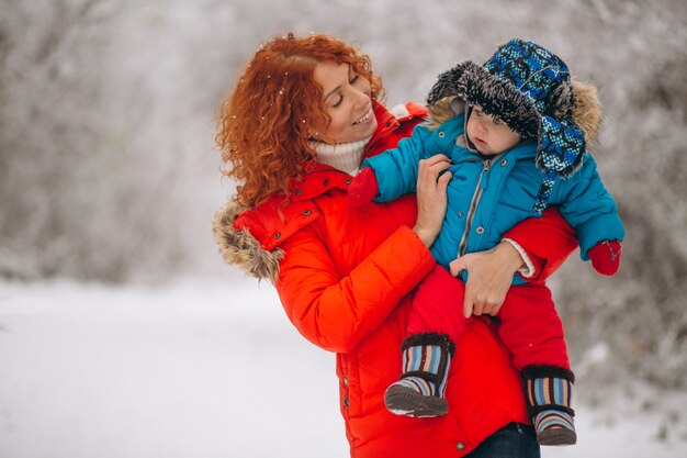 Mutter mit ihrem kleinen Sohn zusammen in einem Winterpark