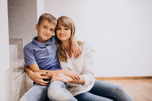 Mutter mit ihrem Sohn zusammen auf dem Boden sitzen