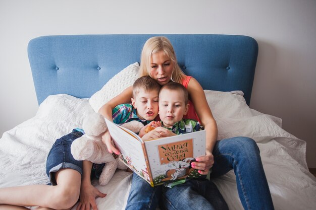 Mutter mit ihren Kindern liest ein Buch