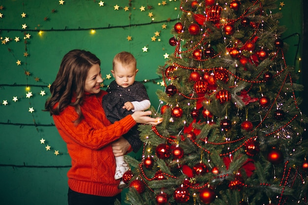 Mutter mit ihrer kleinen Tochter am Weihnachtsbaum