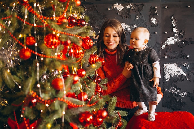 Mutter mit ihrer kleinen Tochter am Weihnachtsbaum