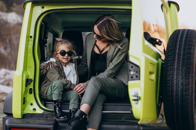 Mutter mit ihrer kleinen Tochter, die hinten im Auto sitzt