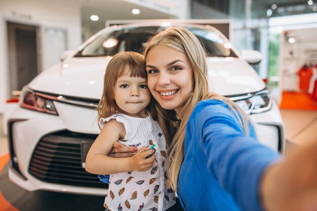 Mutter mit ihrer kleinen Tochter, die vor einem Auto steht