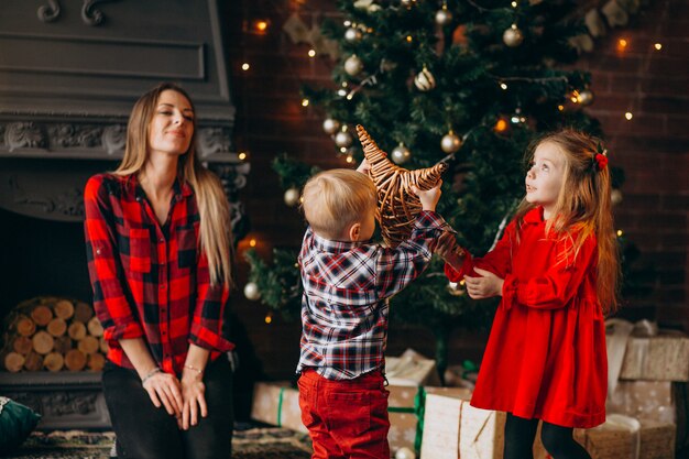 Mutter mit Kindern am Weihnachtsbaum