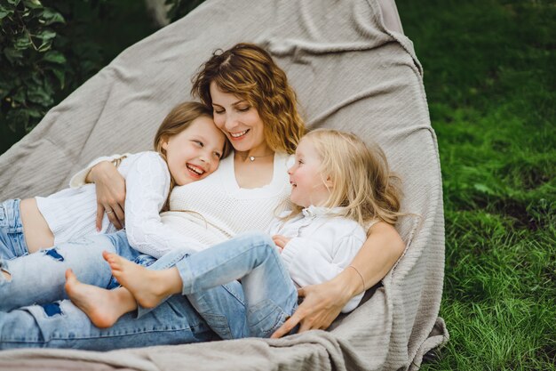 Mutter mit Kindern, die Spaß in einer Hängematte haben. Mutter und Kinder in einer Hängematte.