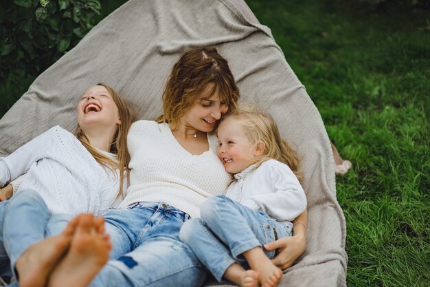 Mutter mit Kindern, die Spaß in einer Hängematte haben. Mutter und Kinder in einer Hängematte.