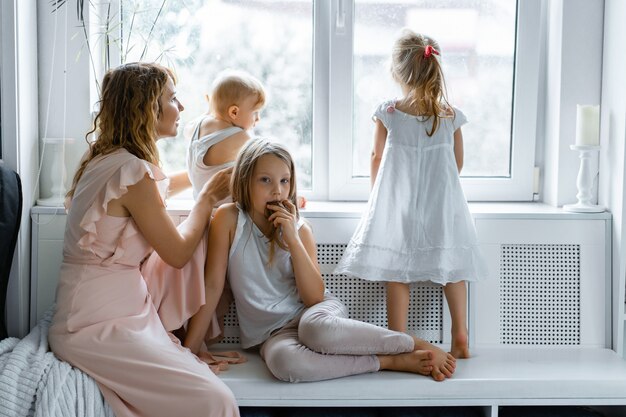 Mutter mit Kindern in familiärer Atmosphäre. Kinder am Fenster