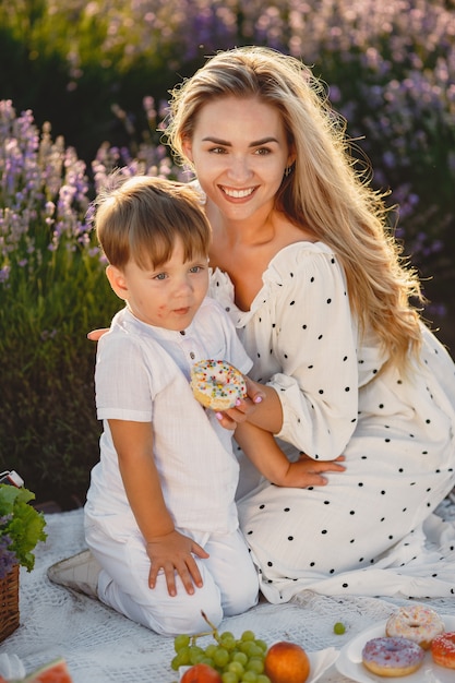 Mutter mit kleinem Sohn auf Lavendelfeld. Frau auf einem Picknick mit Sohn.