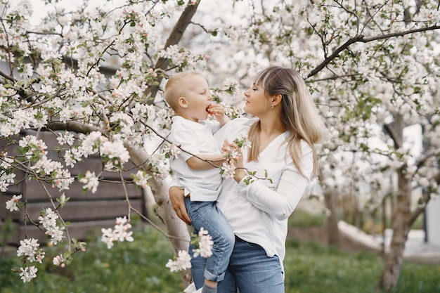 Kostenloses Foto mutter mit kleinem sohn, der in einem sommerhof spielt