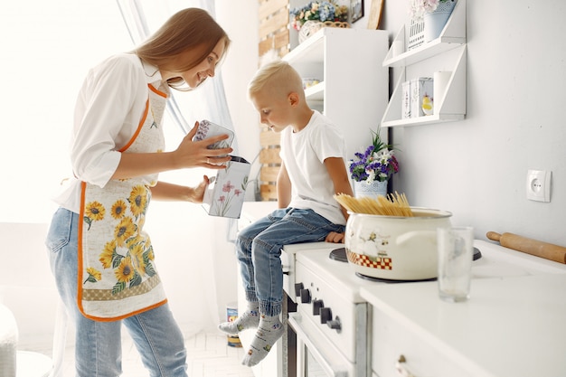 Mutter mit kleinen Kindern, die zu Hause kochen