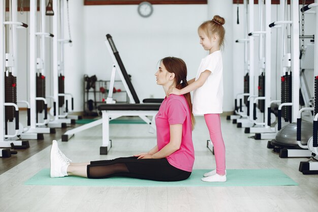 Mutter mit kleiner Tochter nehmen an Gymnastik in der Turnhalle teil