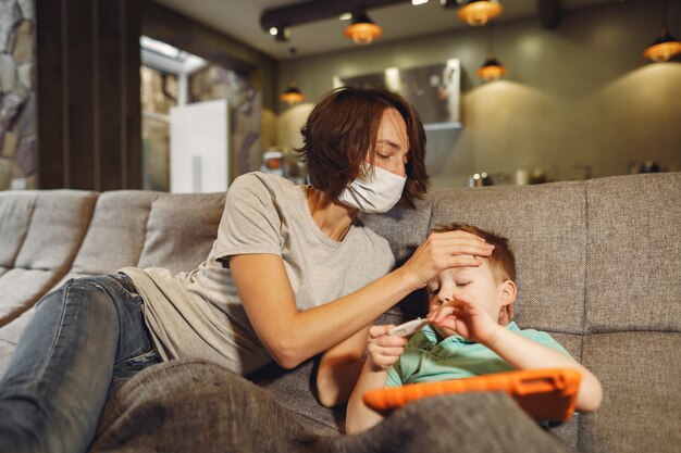 Mutter mit kleinerem Sohn, der zu Hause in der Quarantäne sitzt