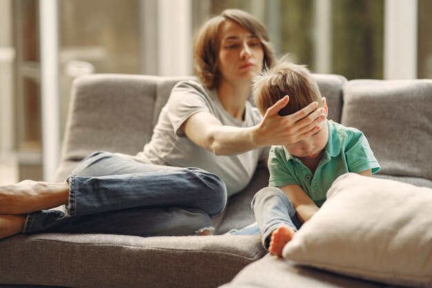 Mutter mit kleinerem Sohn, der zu Hause in der Quarantäne sitzt