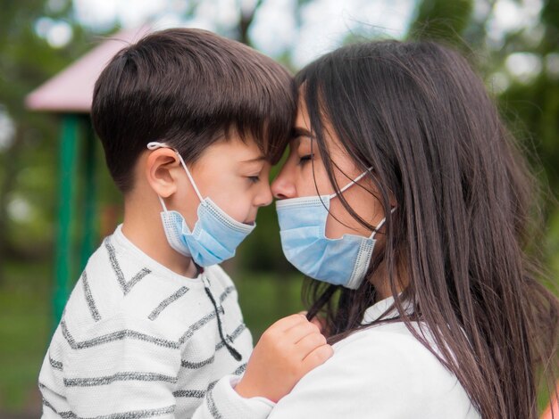 Mutter mit Lesebrille und Kind mit medizinischen Masken