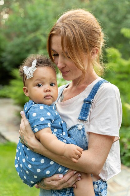 Mutter mit mittlerem Schuss, die Baby hält