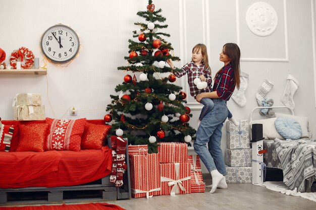 Mutter mit netter Tochter zu Hause mit Weihnachtsgeschenken