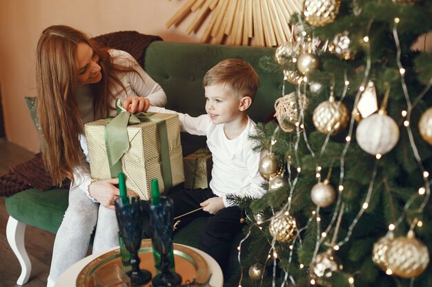 Mutter mit niedlichem Sohn nahe Weihnachtsbaum