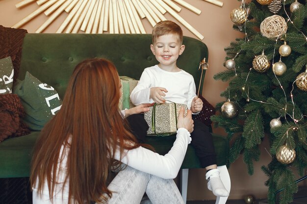 Mutter mit niedlichem Sohn nahe Weihnachtsbaum