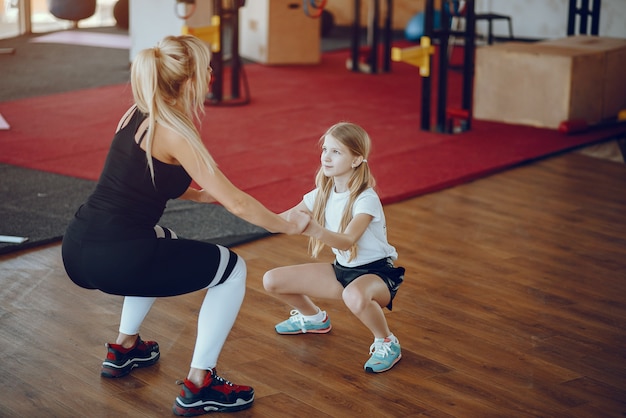 Mutter mit süßer Tochter spielen Sport im Fitnessstudio