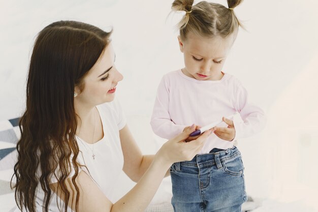 Mutter mit Thermometer sitzt in der Nähe der Tochter