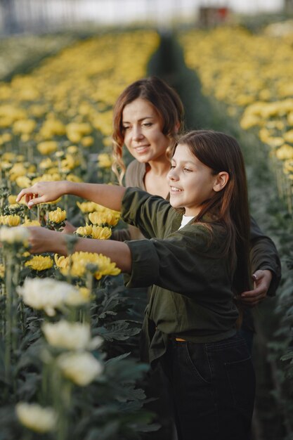 Mutter mit Tochter. Arbeiter mit Blumenstielen. Mädchen in einem grünen Hemd