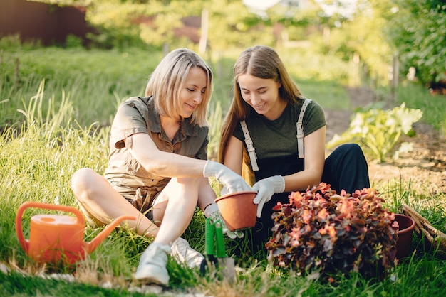 Mutter mit Tochter arbeitet in einem Garten in der Nähe des Hauses