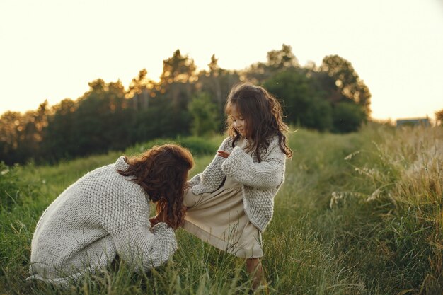 Mutter mit Tochter, die in einem Sommerfeld spielt