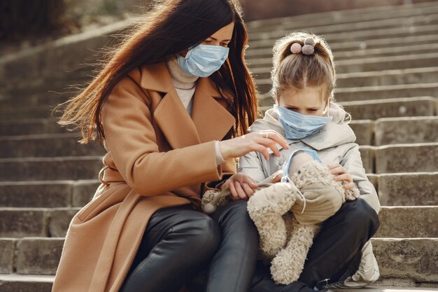 Mutter mit Tochter geht in Masken nach draußen