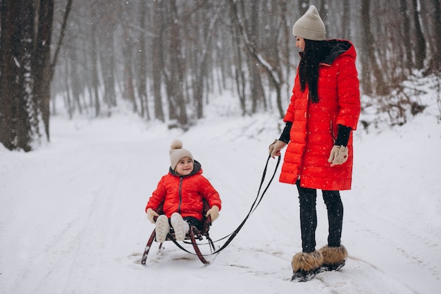 Mutter mit Tochter im Winterparkrodeln